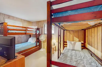 two bunk beds in a room with a tv at Farmhouse on the Road in Wilmington