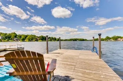 a wooden dock with a chair on the water at Lakefront Home, Close to Mt Southington! in Wolcott