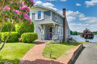 a house with a brick walkway in front of the water at Lakefront Home, Close to Mt Southington! in Wolcott