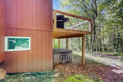 a tree house with a deck on the side of it at Green Mountain Escape in Wilmington