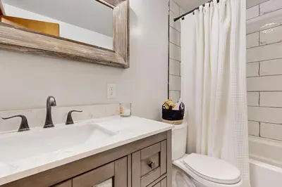 a bathroom with a sink and a toilet and a mirror at Green Mountain Escape in Wilmington