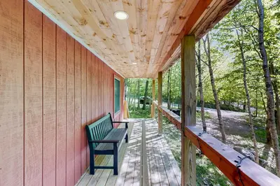 a porch of a house with a bench on it at Green Mountain Escape in Wilmington