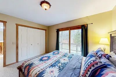 a bedroom with a bed and a window at Wooded Wonder in West Dover