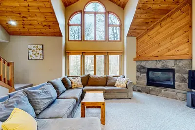 a living room with a couch and a fireplace at Wooded Wonder in West Dover