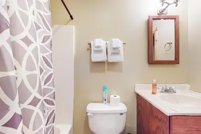 a bathroom with a toilet and a sink and a mirror at Wooded Wonder in West Dover