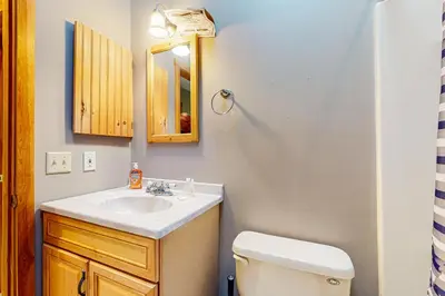 a bathroom with a sink and a toilet and a mirror at Wooded Wonder in West Dover