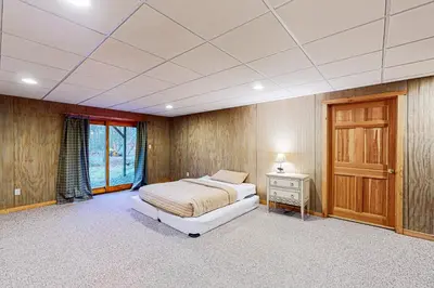 a bedroom with a bed and a table and a door at Wooded Wonder in West Dover