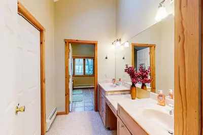 a bathroom with two sinks and a large mirror at Wooded Wonder in West Dover