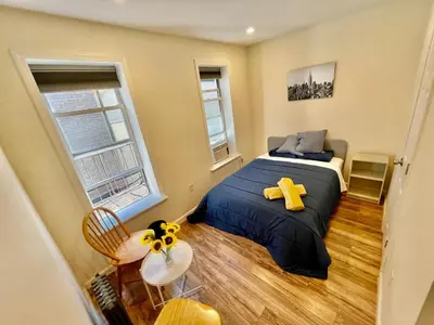a bedroom with a bed with a yellow teddy bear on it at 2 Bedrooms Flat 5 minutes from TIMES SQUARE in Long Island City