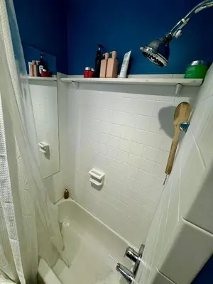 a bathroom with a white tub and a blue wall at 2 Bedrooms Flat 5 minutes from TIMES SQUARE in Long Island City