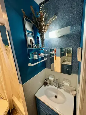a bathroom with a sink and a blue wall at 2 Bedrooms Flat 5 minutes from TIMES SQUARE in Long Island City