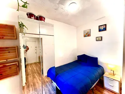 a blue bed in a room with a person taking a picture at 2 Bedrooms Flat 5 minutes from TIMES SQUARE in Long Island City