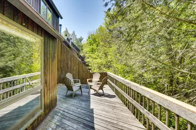 a wooden deck with two chairs and a table on it at Fantastic 2 family vacation home with EV charger in Windham