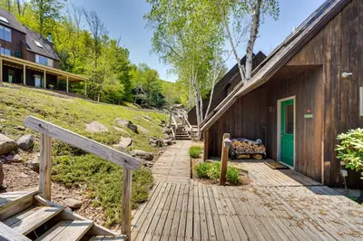 a wooden pathway leading to a house with a green door at Fantastic 2 family vacation home with EV charger in Windham