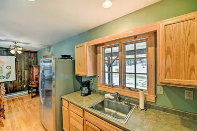 a kitchen with a stainless steel refrigerator and wooden cabinets at West Dover Home with Deck about 2 Mi to Mount Snow! in West Dover