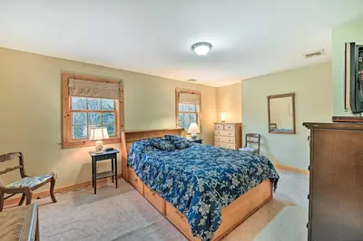 a bedroom with a bed and a chair and a mirror at West Dover Home with Deck about 2 Mi to Mount Snow! in West Dover