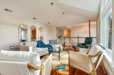 a living room with white furniture and windows at Hudson River Views Briarcliff Manor Home with Deck in Briarcliff Manor