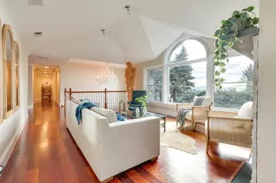 a living room with a white couch and windows at Hudson River Views Briarcliff Manor Home with Deck in Briarcliff Manor
