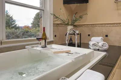 a bathroom sink with a bottle of wine and a wine glass at Hudson River Views Briarcliff Manor Home with Deck in Briarcliff Manor