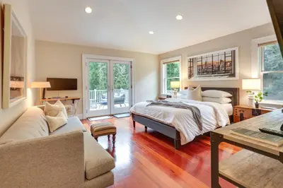 a bedroom with a bed and a couch and a table at Hudson River Views Briarcliff Manor Home with Deck in Briarcliff Manor