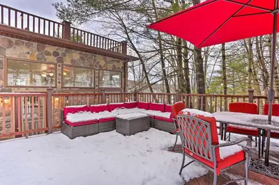 a patio with a red umbrella and a table and chairs at 1 Mi to Lake Wallenpaupack Spacious Poconos Villa in Hawley