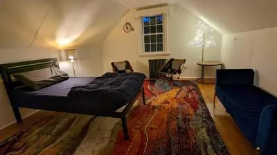 a bedroom with a bed and a couch in a room at Live the Walkable Darien Lifestyle in this Charming Noroton Heights Gem! in Darien