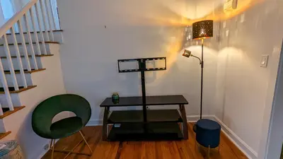 a room with a table and a green chair at Live the Walkable Darien Lifestyle in this Charming Noroton Heights Gem! in Darien