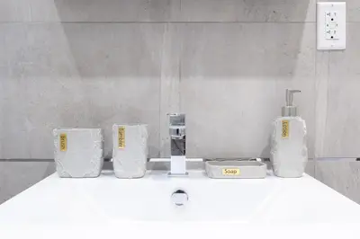 a bathroom sink with three towels and a bottle of soap at 317-4A NEW Modern 1BR W&D Walk to Central Park in New York