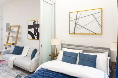 a bedroom with a bed and a chair and a mirror at 317-4A NEW Modern 1BR W&D Walk to Central Park in New York