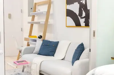 a white living room with a white couch and blue pillows at 317-4A NEW Modern 1BR W&D Walk to Central Park in New York
