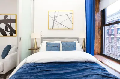 a bedroom with a blue and white bed and a window at 317-4A NEW Modern 1BR W&D Walk to Central Park in New York