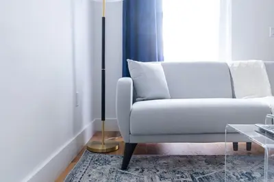 a living room with a white couch and a floor lamp at 323-2 Specious 2BR Williamsburg in Brooklyn