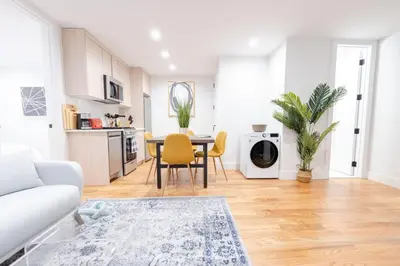 a living room with a table and chairs and a kitchen at 323-1 Specious 2BR Williamsburg in Brooklyn