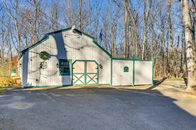 a white and green barn with a gate at Guilford Carriage House at Granite Lodge! in Guilford
