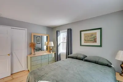 a bedroom with a bed and a dresser and a mirror at Cozy Southern Vermont Home with On-Site Trails in Whitingham