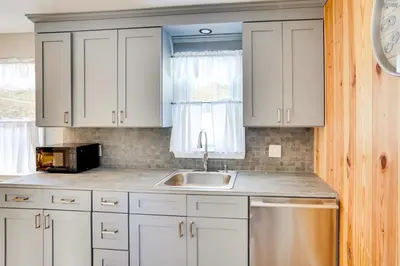 a kitchen with white cabinets and a sink at Cozy Southern Vermont Home with On-Site Trails in Whitingham