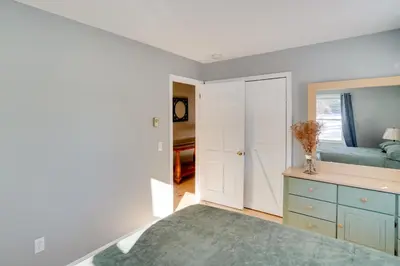a bedroom with a blue bed and a mirror at Cozy Southern Vermont Home with On-Site Trails in Whitingham