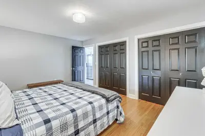 a bedroom with a bed and two brown doors at Modern Middletown Retreat, Minutes to Downtown! in Middletown