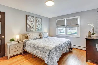 a bedroom with a bed and two windows at Modern Middletown Retreat, Minutes to Downtown! in Middletown