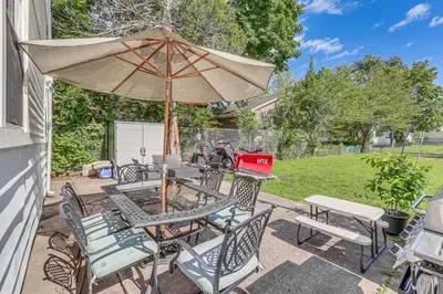 a patio with a table and chairs and an umbrella at Modern Middletown Retreat, Minutes to Downtown! in Middletown