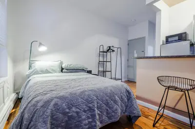 a bedroom with a bed and a chair in it at Park Side Living, Get Cozy! in New York