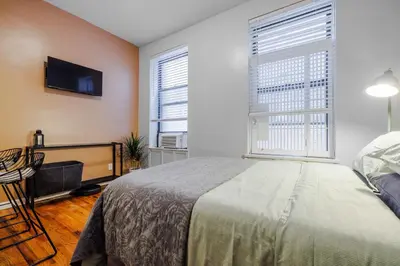 a bedroom with a bed and a flat screen tv at Park Side Living, Get Cozy! in New York
