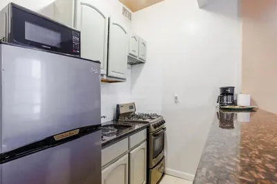 a kitchen with a stainless steel refrigerator with a microwave at Park Side Living, Get Cozy! in New York