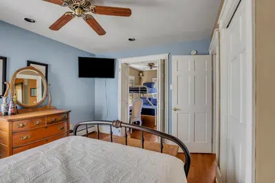 a bedroom with a bed with a ceiling fan and a mirror at A Bonnie Place in Oneonta