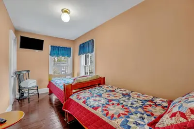a bedroom with two beds and a flat screen tv at Doyle House - Near Cooperstown Dreams Park 2 in Milford