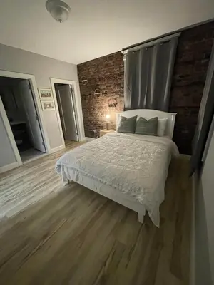 a bedroom with a bed and a brick wall at Modern Luxury Apartment near NYC in Jersey City