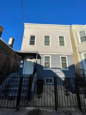 a white house with a fence in front of it at Modern Luxury Apartment near NYC in Jersey City