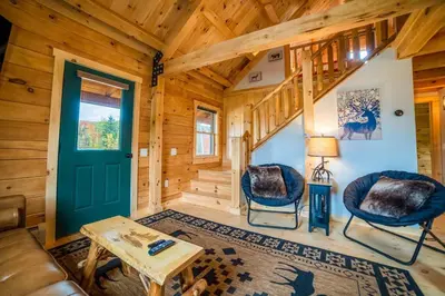 a living room with a green door in a wooden cabin at Florida Mountain Log Cabin in Florida