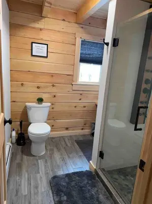 a small bathroom with a toilet and a shower at Florida Mountain Log Cabin in Florida