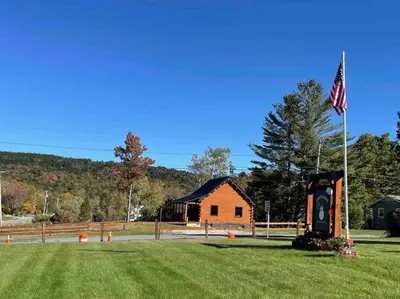 a building with a flag next to a grass field at Florida Mountain Log Cabin in Florida